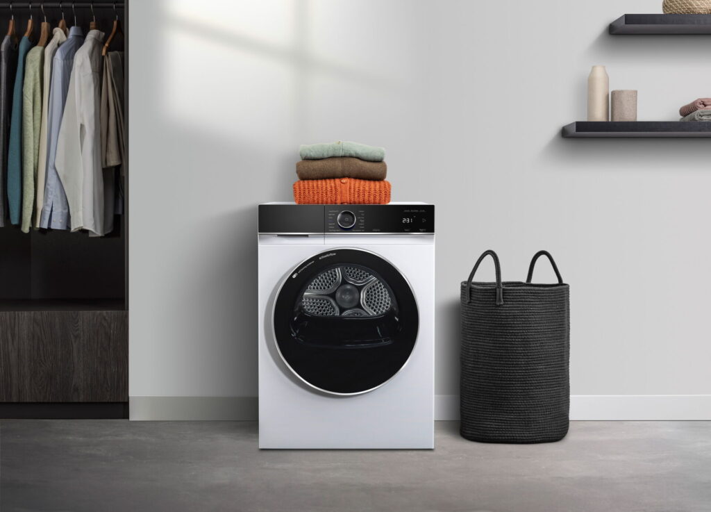 Frei stehende Waschmaschine in einer minimalistischen Waschküche mit Wäschekorb und Wandregalen